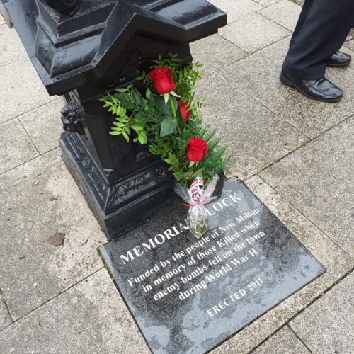 3 red roses laid in Remembrance at the New Milton Memorial Clock