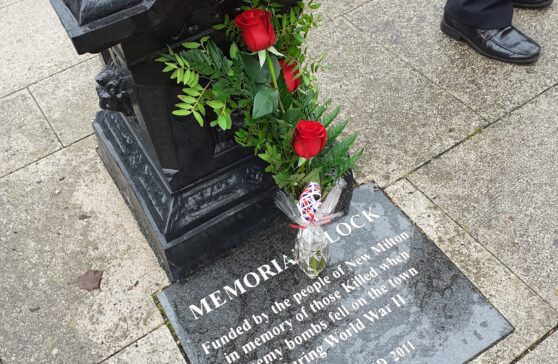 3 red roses laid in Remembrance at the New Milton Memorial Clock